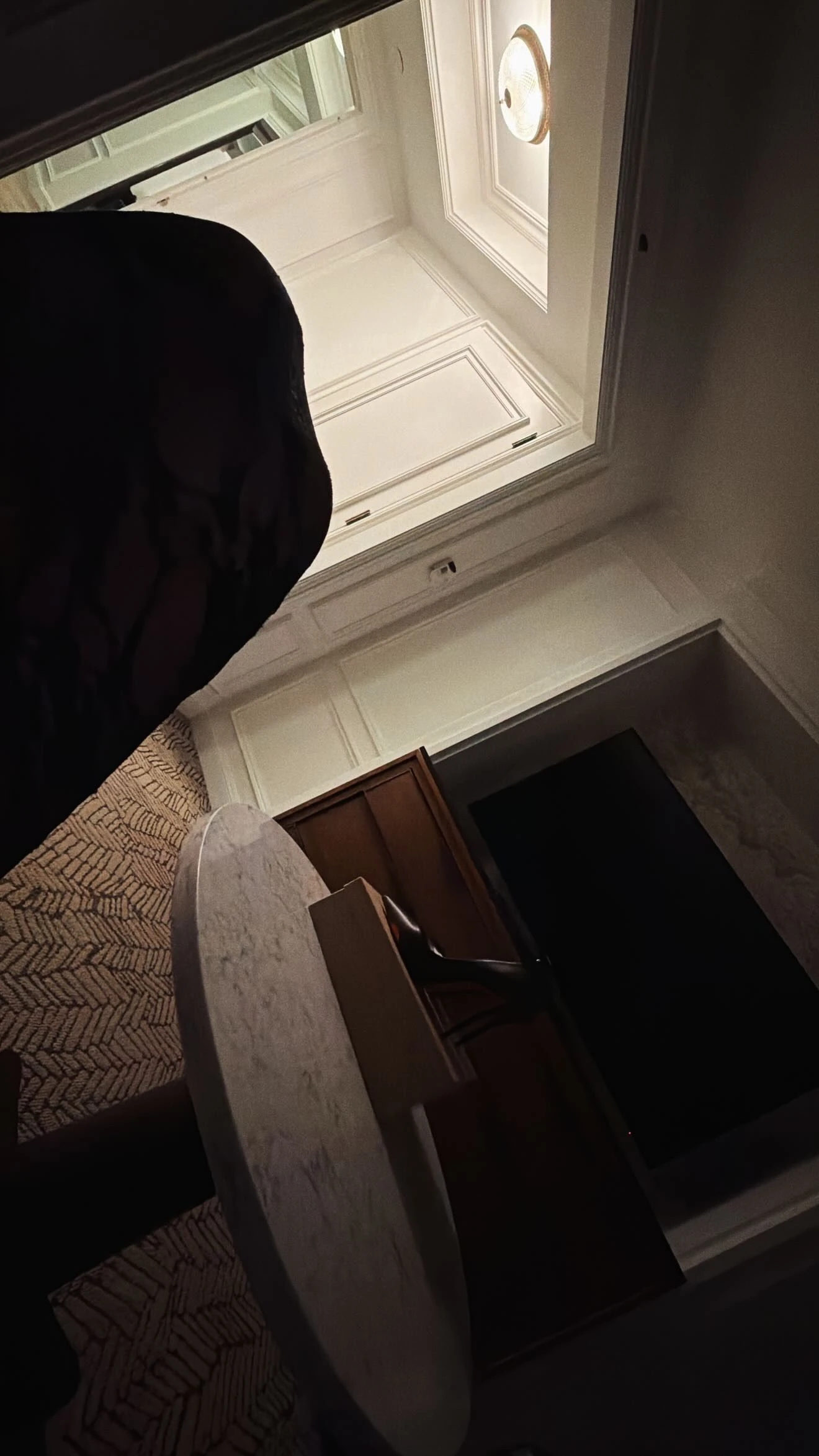 A tilted, low-light camera-roll glimpse of a heel and the room.